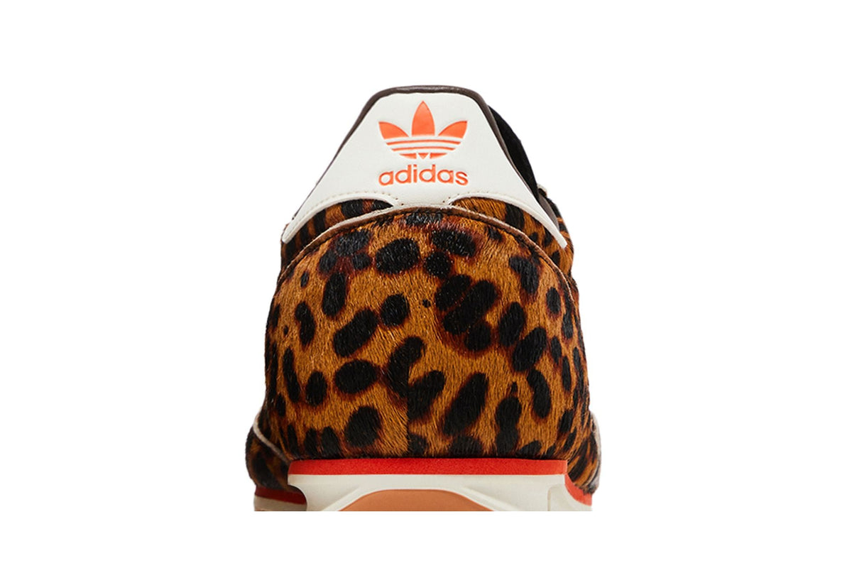 Gros plan du talon d'une Adidas SL 72 OG léopard en poils de poney, logo adidas orange sur fond crème