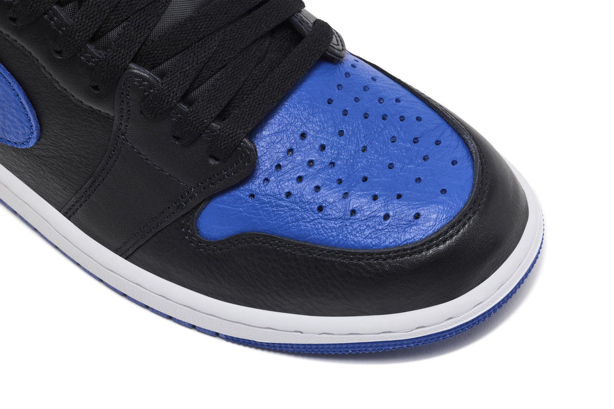 Gros plan sur le bout perforé bleu roi et le cuir noir de la Air Jordan 1 Royal 2026