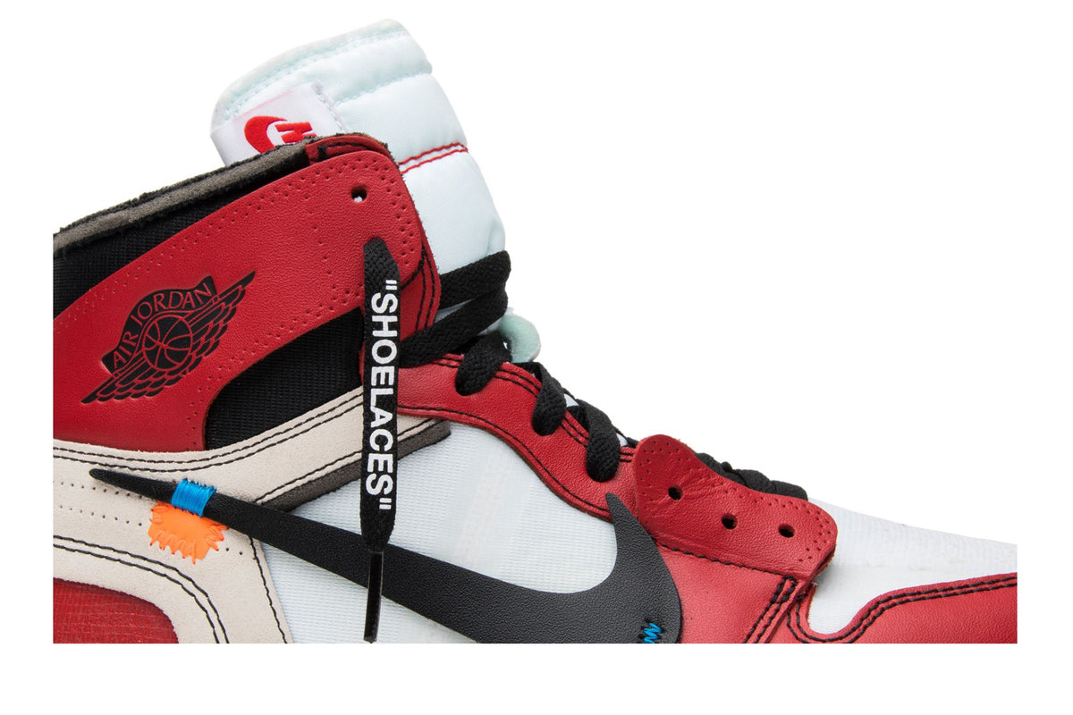 Gros plan de l'Air Jordan 1 Off-White Chicago The Ten : lacet imprimé « SHOELACES », attache plastique orange et Swoosh noir sur cuir rouge et blanc