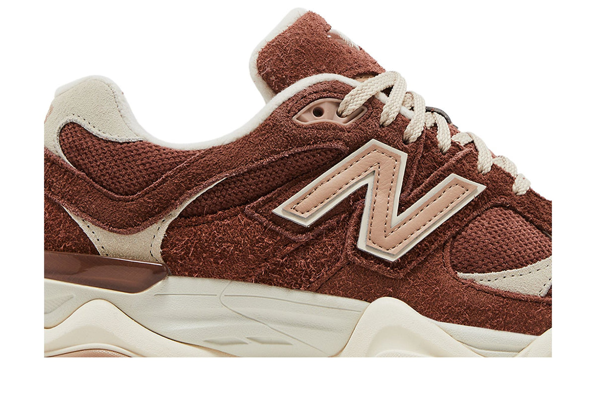 Gros plan d'une New Balance 9060 Rich Oak en daim marron roux, logo N beige et mesh ton sur ton