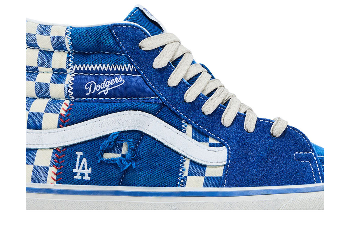 Gros plan sur la Vans Sk8-Hi Dodgers : daim bleu, damier bleu et blanc, couture rouge façon balle de baseball et logo LA